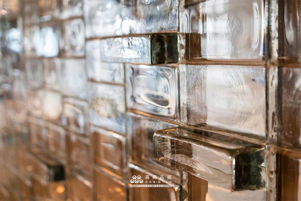 實心玻璃磚水波光膠築工法,凹凸造型排列,呈現出整面實心磚玻璃牆生動立體的光影效果。